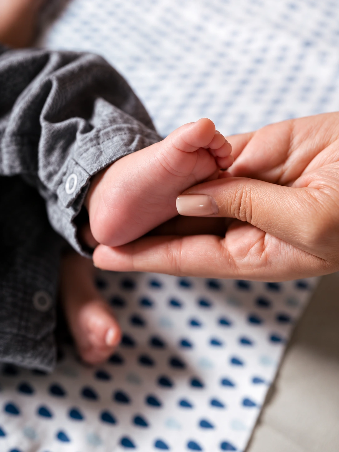 Piecito de un bebé sostenido con suavidad por una mano