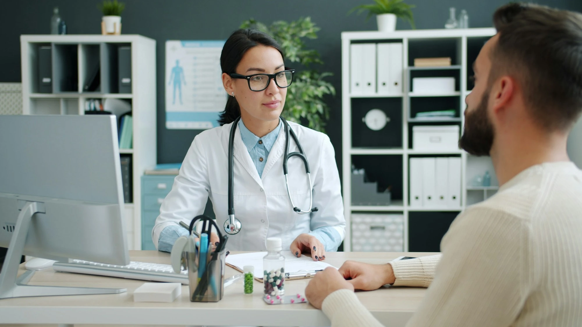 Una médica conversa con una persona durante una consulta