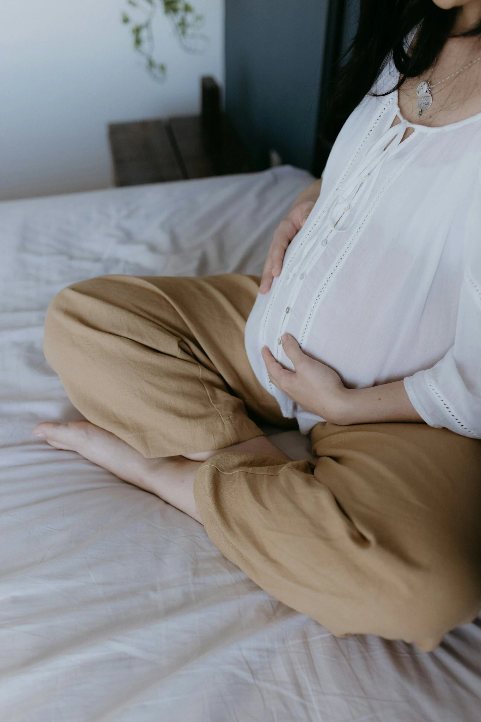 Una mujer embarazada descansa con las manos sobre su vientre