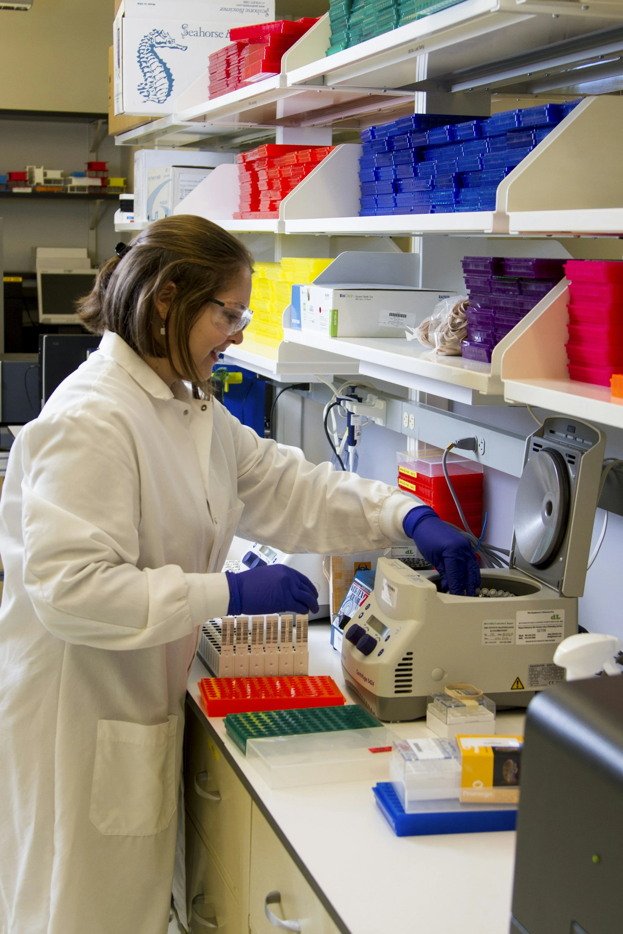 Una profesional con bata y guantes prepara muestras en el laboratorio