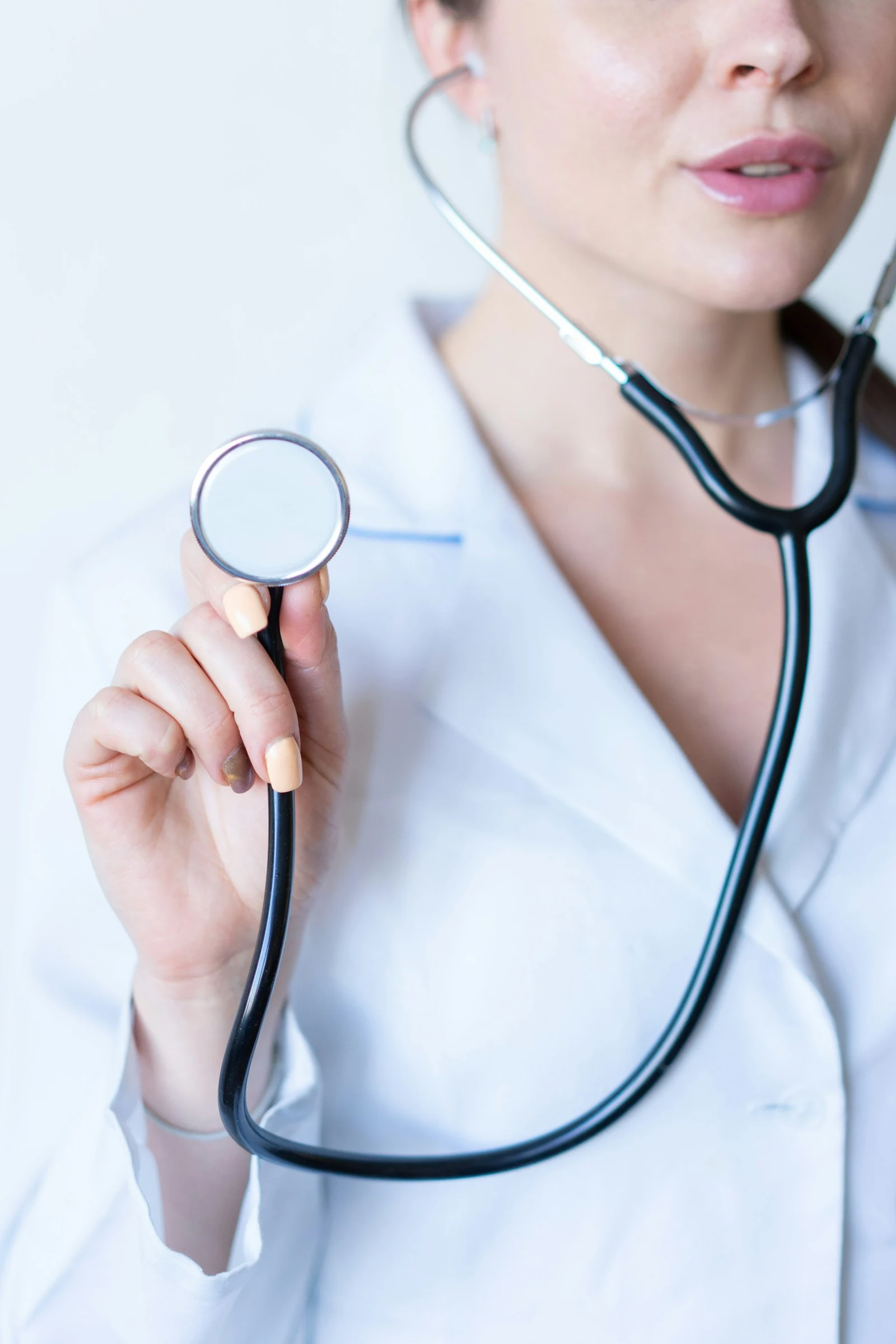 Una profesional de salud sostiene un estetoscopio